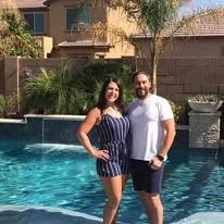 Two people beside a swimming pool